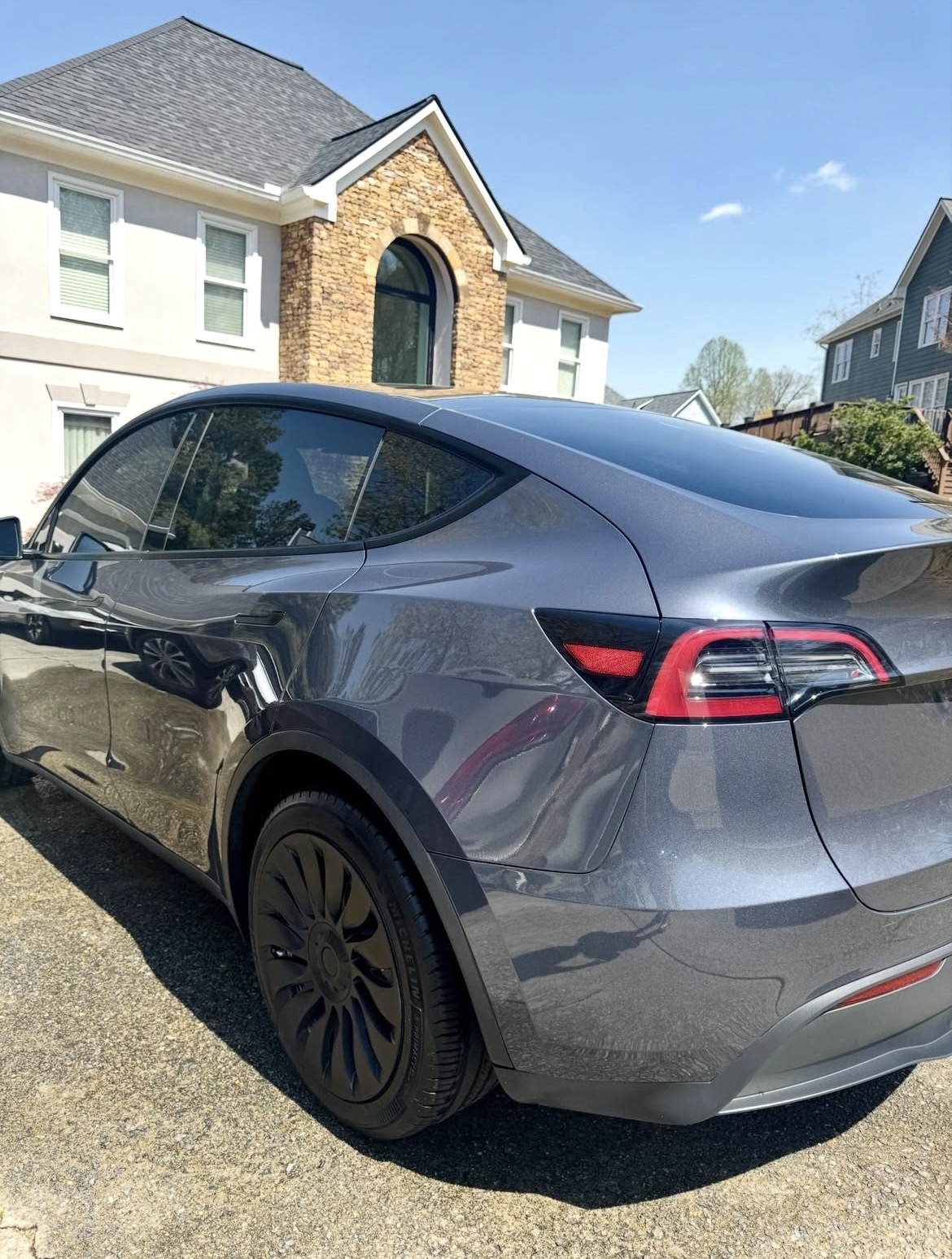 Tesla Model Y rear three-quarter, reflective paint